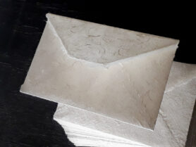 На просвет конверта видны тонкие ажурные волокна бумаги ручной работы // Студия бумаги и дизайна Лектон